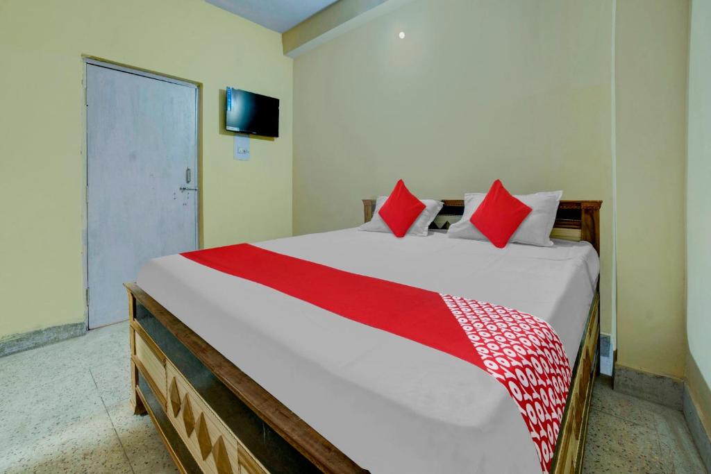 a bedroom with a large bed with red pillows at OYO Flagship Hotel Sweet And Soul in Jamshedpur