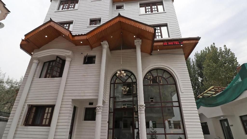 a large white building with a roof on top at Hotel de elaaf in Srinagar