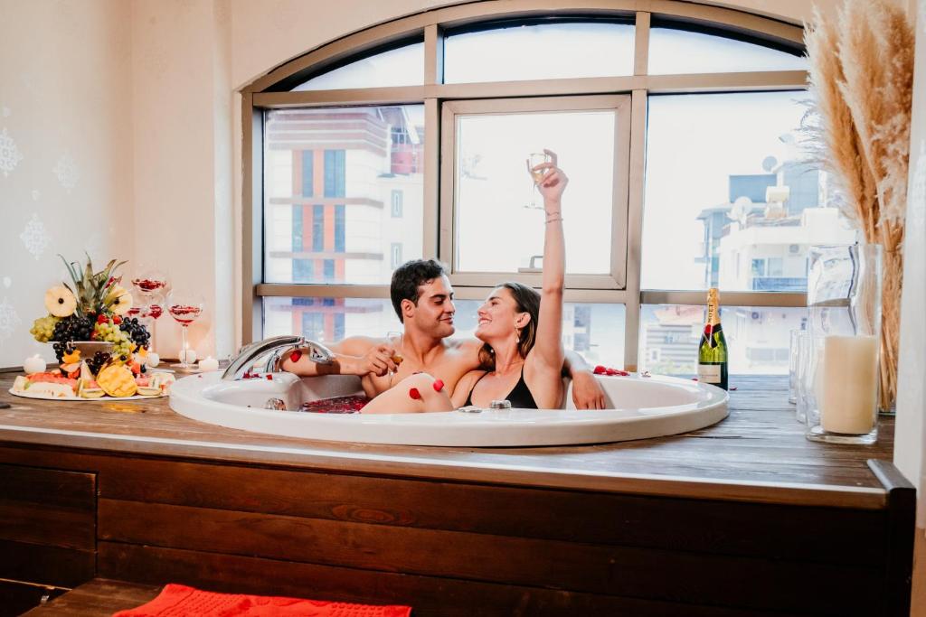 a man and woman sitting in a bath tub at Tac Premier Hotel & Spa in Alanya