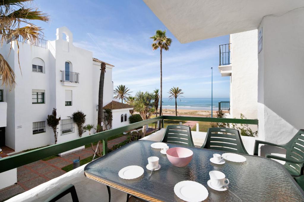 a table on a balcony with a view of the ocean at Barrosamar - Primera línea de playa in Chiclana de la Frontera