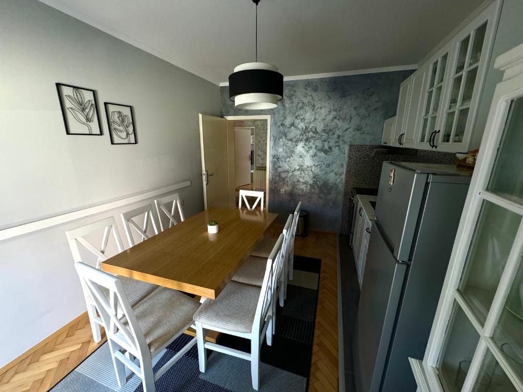 een keuken en eetkamer met een houten tafel en stoelen bij Apartman Tadeus in Soko Banja