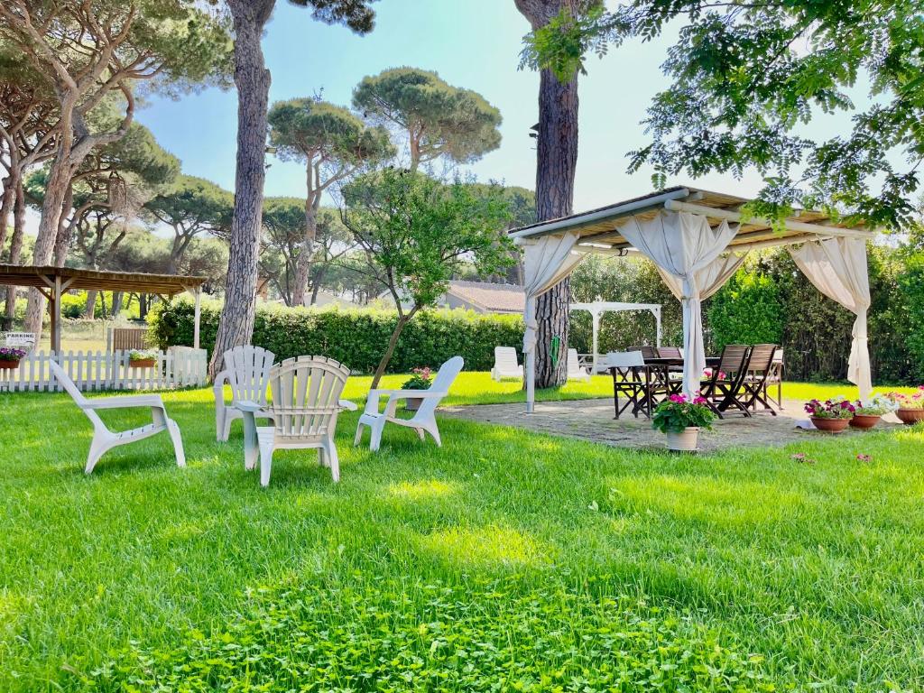 een groep stoelen en een tuinhuisje in een tuin bij La Meria di Maria Casa Arancio in Marina di Grosseto