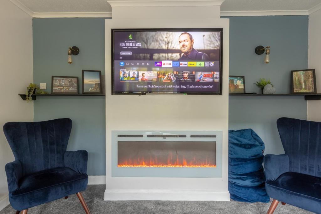 a living room with a fireplace and a flat screen tv at Ideal 3 Bed Home In Glasgow City With Free Parking in Glasgow