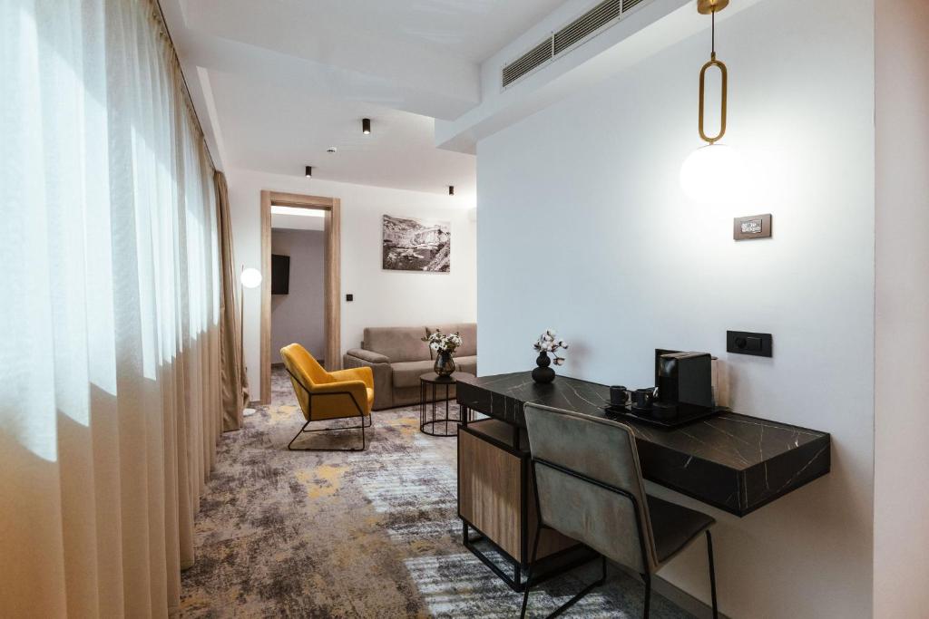 a corridor of a hotel room with a desk and chairs at City Hotel Dubrovnik in Dubrovnik