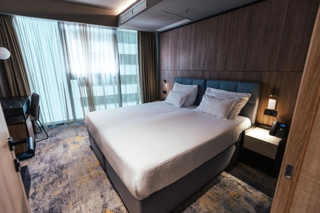 a bedroom with a large bed and a large window at City Hotel Dubrovnik in Dubrovnik