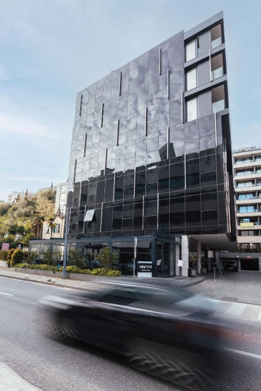 a car driving past a building on a street at City Hotel Dubrovnik in Dubrovnik