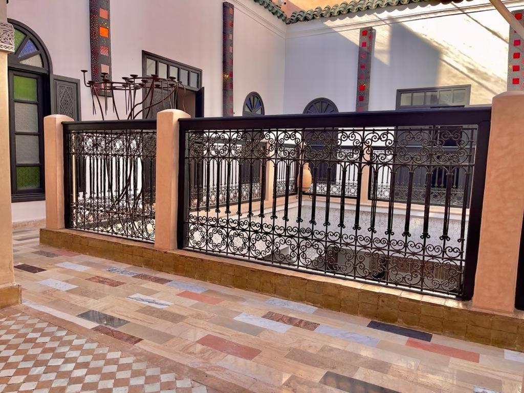 a black gate in a building with a tile floor at Riad Ta'achchaqa in Marrakesh