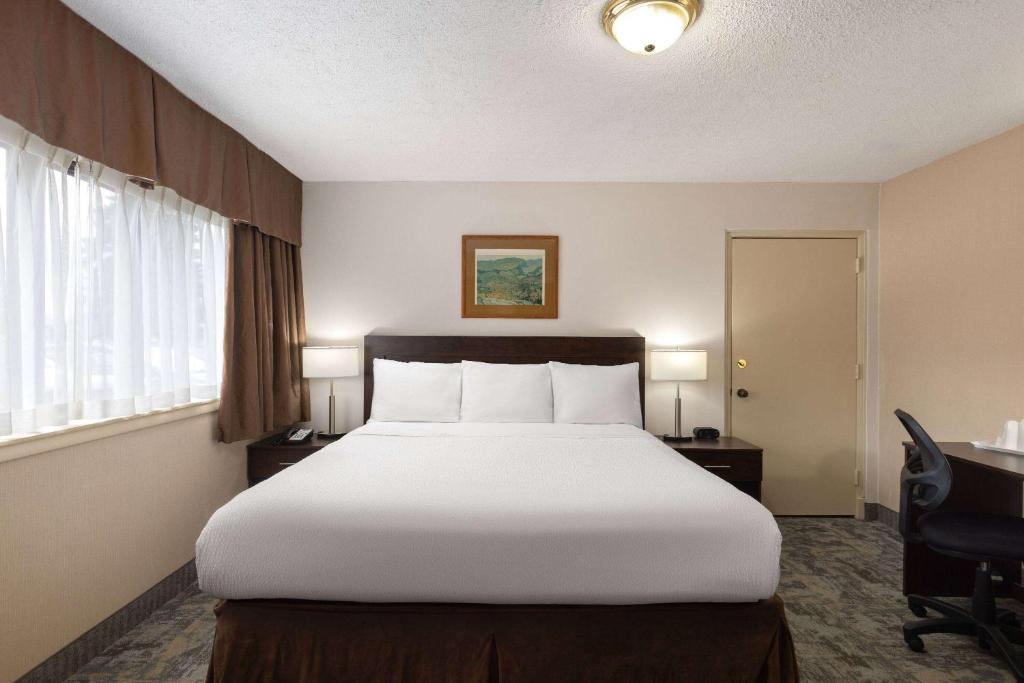 ein Schlafzimmer mit einem großen Bett in einem Hotelzimmer in der Unterkunft Travelodge by Wyndham Thunder Bay ON in Thunder Bay