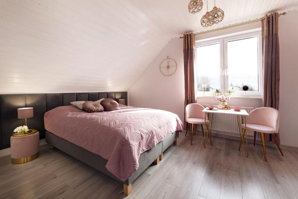 a bedroom with a bed and a table with chairs at Pokoje Gościnne Pod Lipami in Kudowa-Zdrój