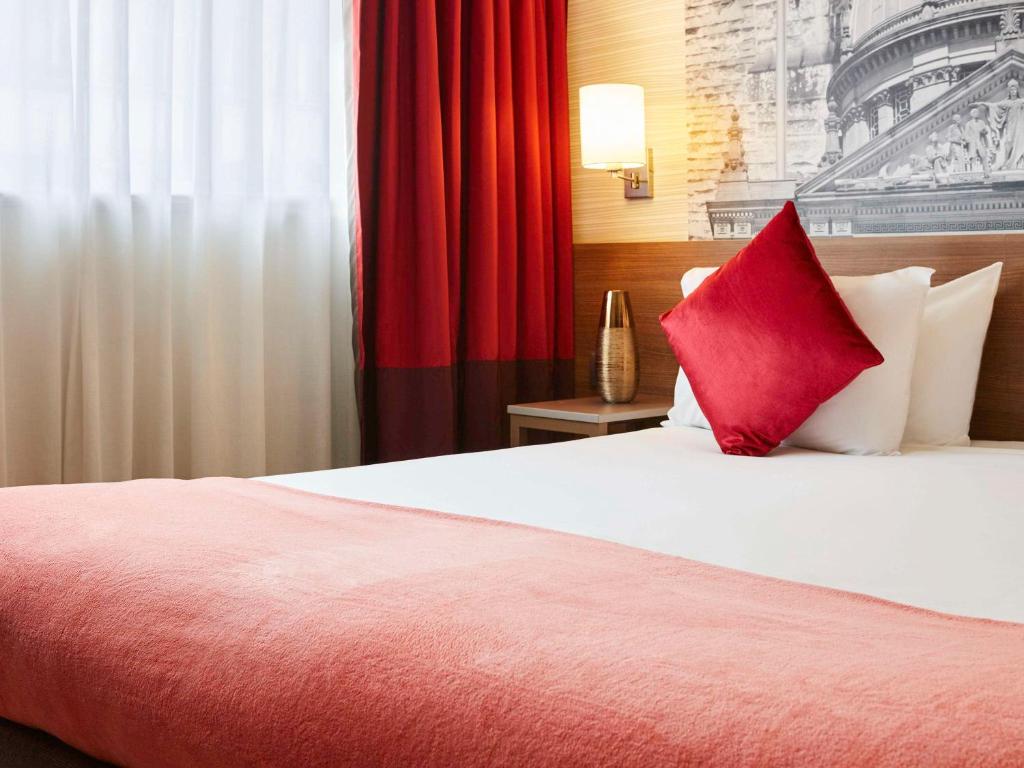 a hotel room with a bed with a red pillow at Aparthotel Adagio Birmingham City Centre in Birmingham