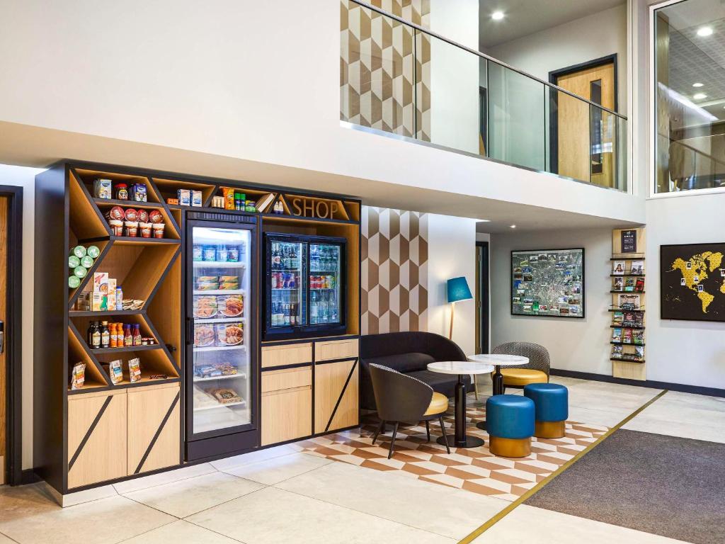 a fast food restaurant with a table and a refrigerator at Aparthotel Adagio Birmingham City Centre in Birmingham