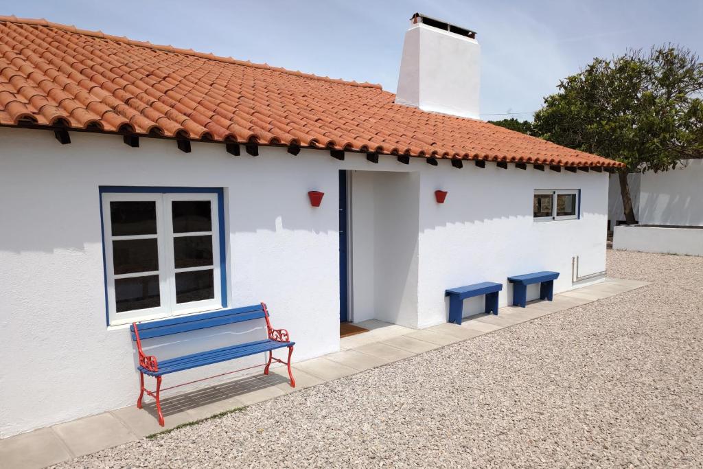 a blue bench in front of a white building at Alentempo in Aldeia de Brescos