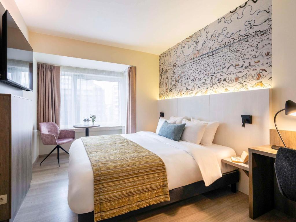 ein Hotelzimmer mit einem Bett und einem Fenster in der Unterkunft Mercure Oostende in Ostende