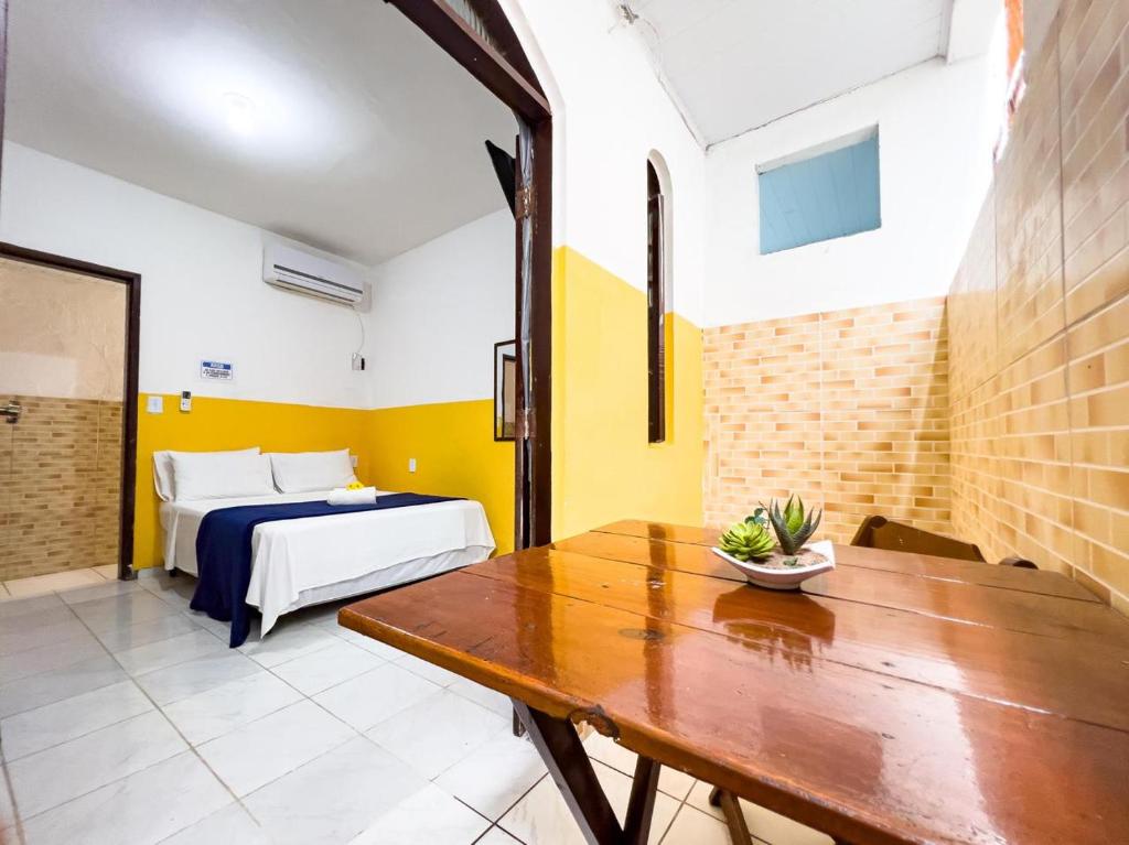 a room with a bed and a wooden table at Pousada Sol e Mar in Morro de São Paulo
