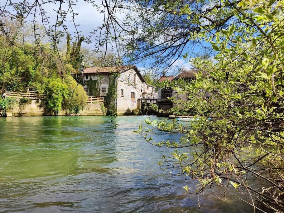 vistas a un río con casas y árboles en Moulin de Courcelles en Aubréville