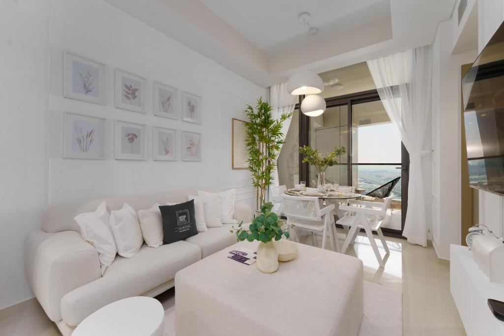 - un salon blanc avec un canapé blanc et une table dans l'établissement Maison Privee - City Chic Retreat in Dubai Prime Location, à Dubaï