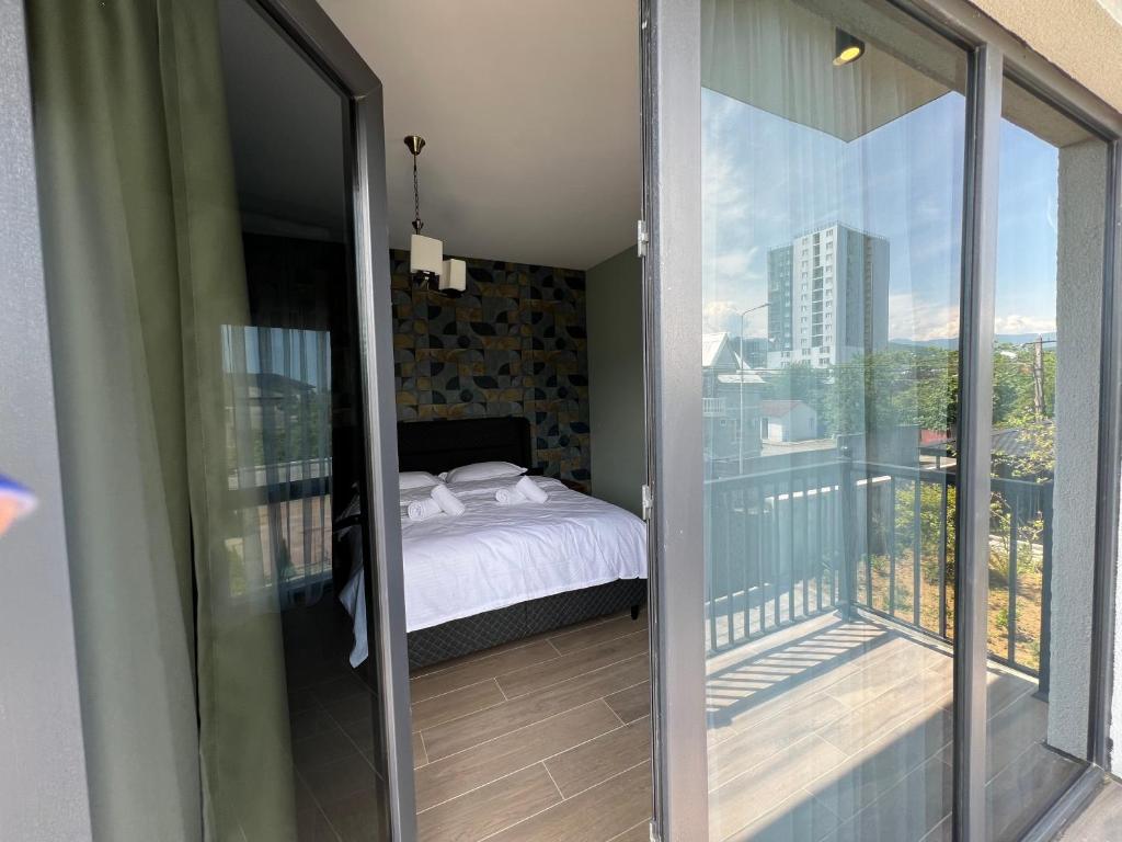 1 dormitorio con 1 cama en el balcón en Feel Georgia, en Batumi