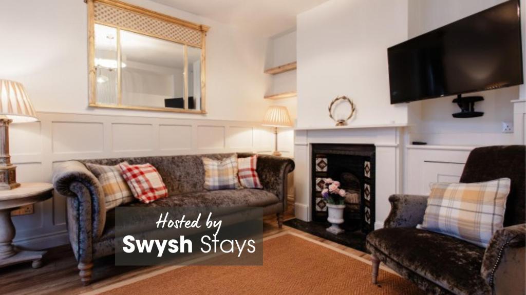 uma sala de estar com um sofá e uma lareira em Didi's Cottage em Cowes