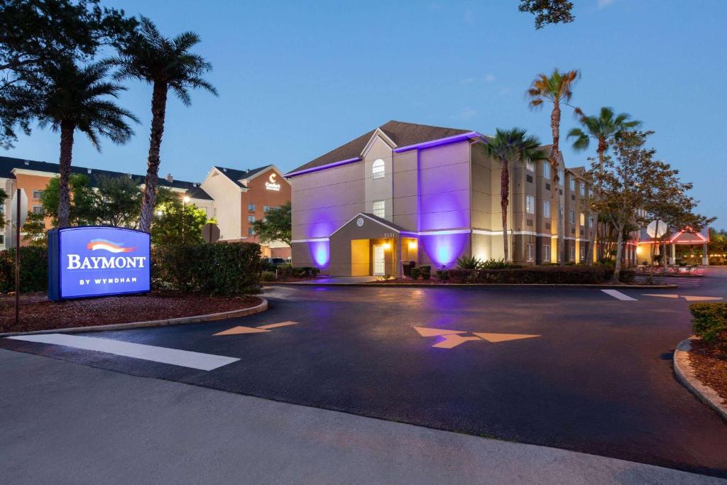 a building with a sign in a parking lot at Baymont by Wyndham Orlando-International Dr-Universal Blvd in Orlando