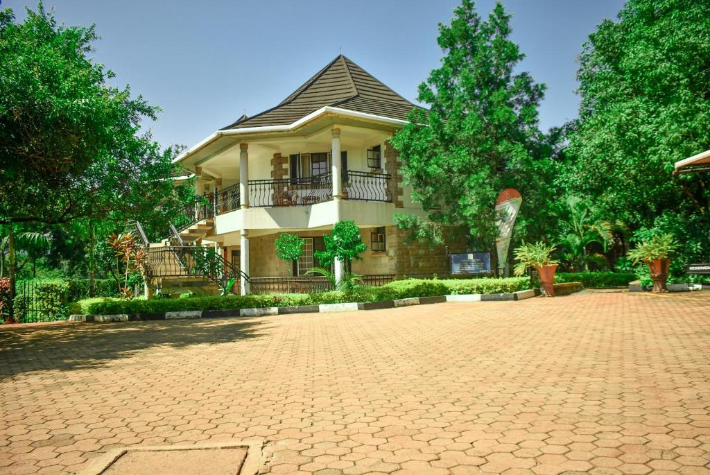 a large house with a brick driveway in front of it at Desert Rose Resort Kisumu in Kisumu