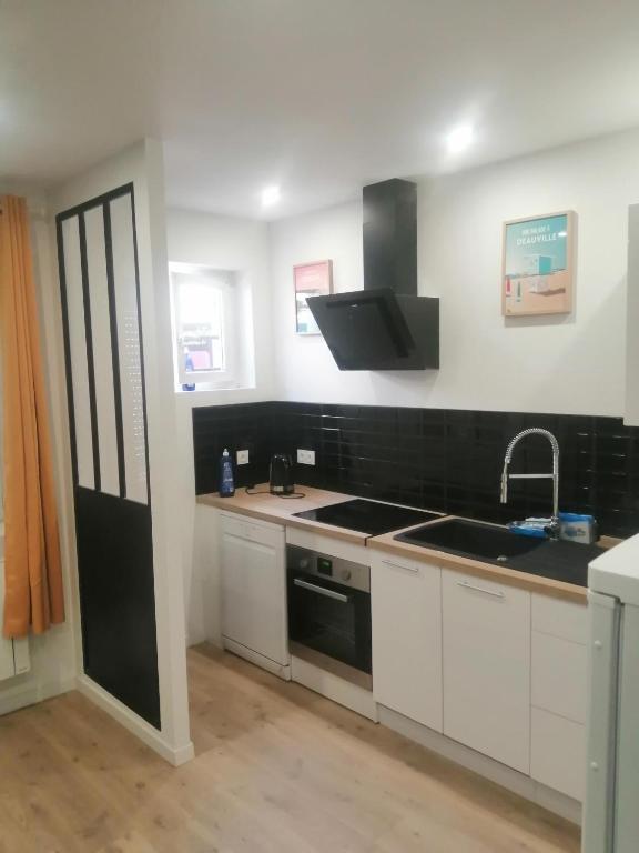 une cuisine avec un évier et une cuisinière dans l'établissement Confort et sérénité 5 Min Plage, au Havre