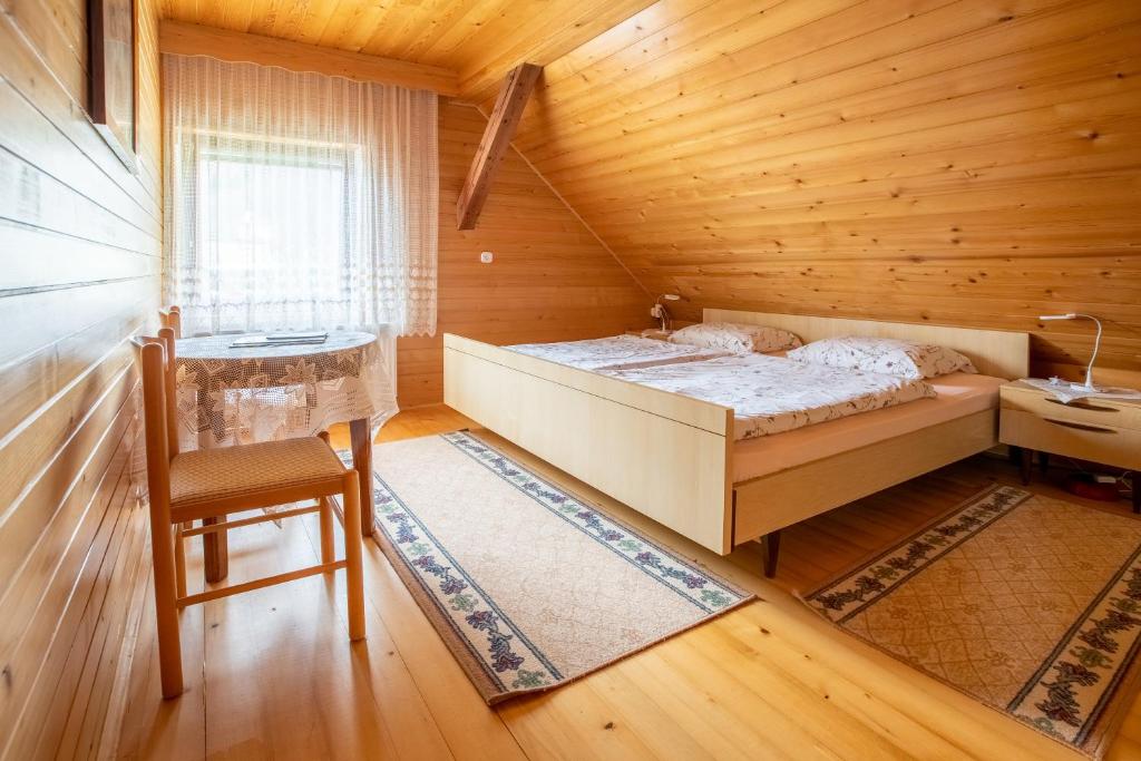 1 dormitorio con 1 cama en una cabaña de madera en Apartmaji Skantar, en Bohinj