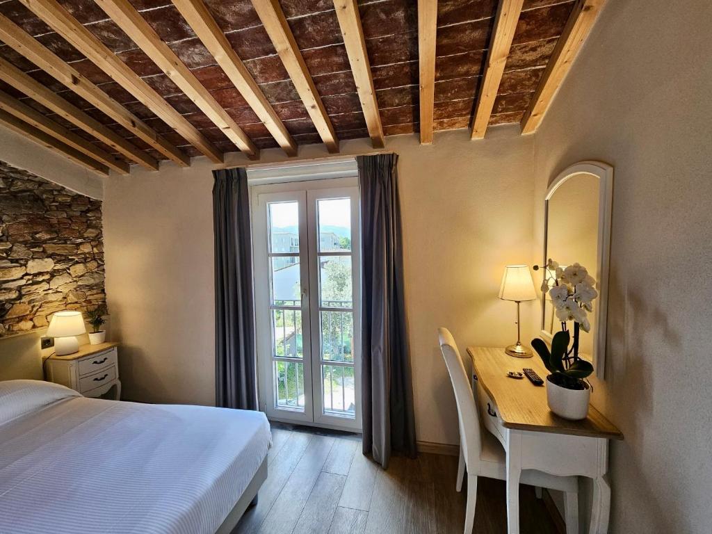 a bedroom with a bed and a desk and a window at Il Tiglio Jacuzzi&Sauna in Lucca