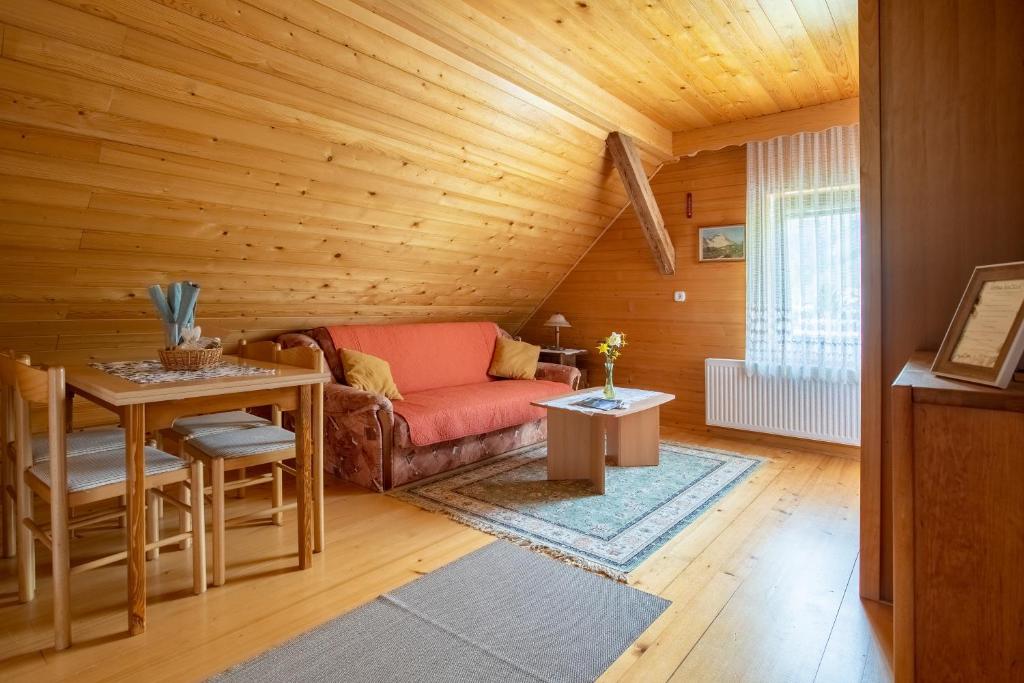 a living room with a couch and a table at V objemu gora in Bohinj