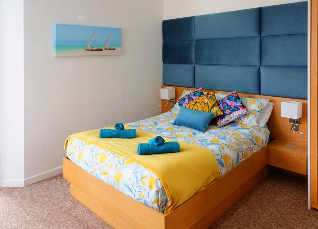 ボーンマスにあるA Beautiful Apartment with Stunning Sea Views & Private Balconyのベッドルーム1室(青いタオル2枚付)