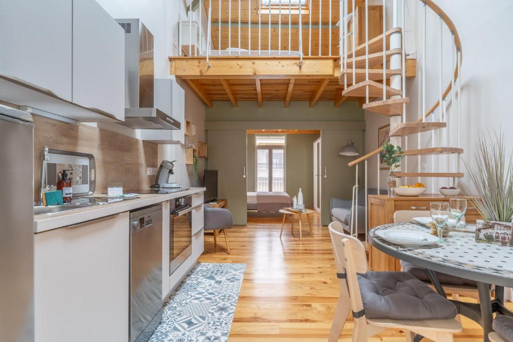 Il dispose d'une cuisine et d'un salon avec une table et un escalier en colimaçon. dans l'établissement La Thibaudière - Appt en centre-ville, à Arcachon