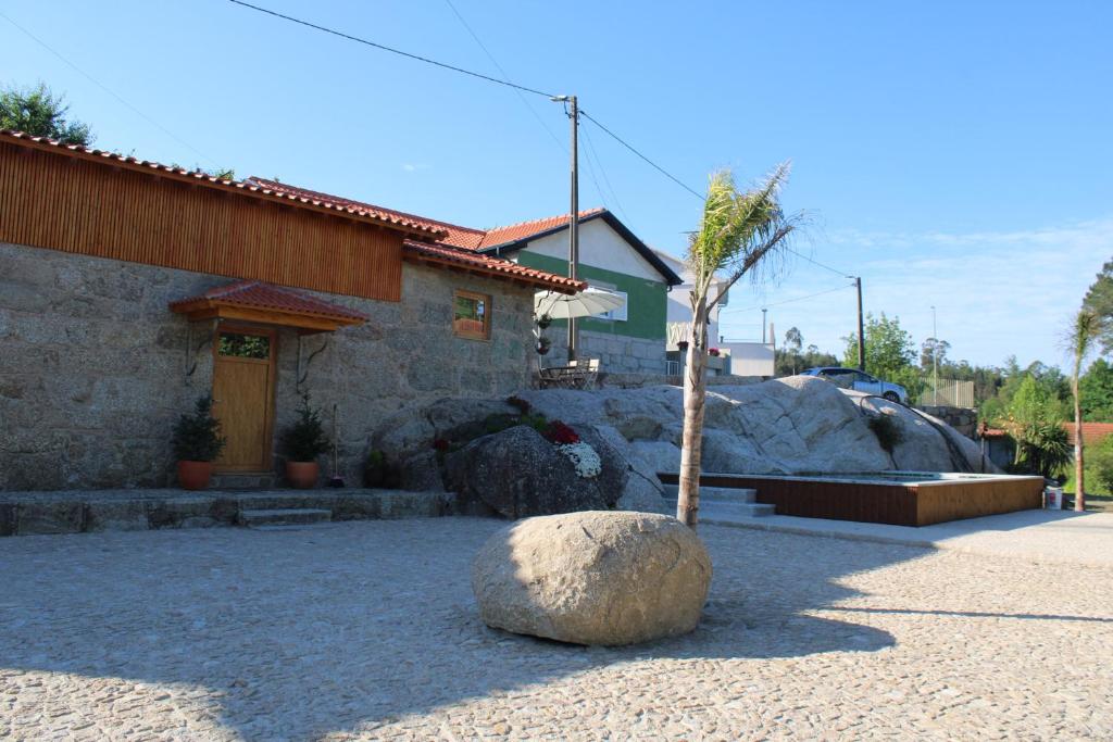 une maison avec un arbre et un rocher devant elle dans l'établissement Casa Ponte de Espindo, à Lousada