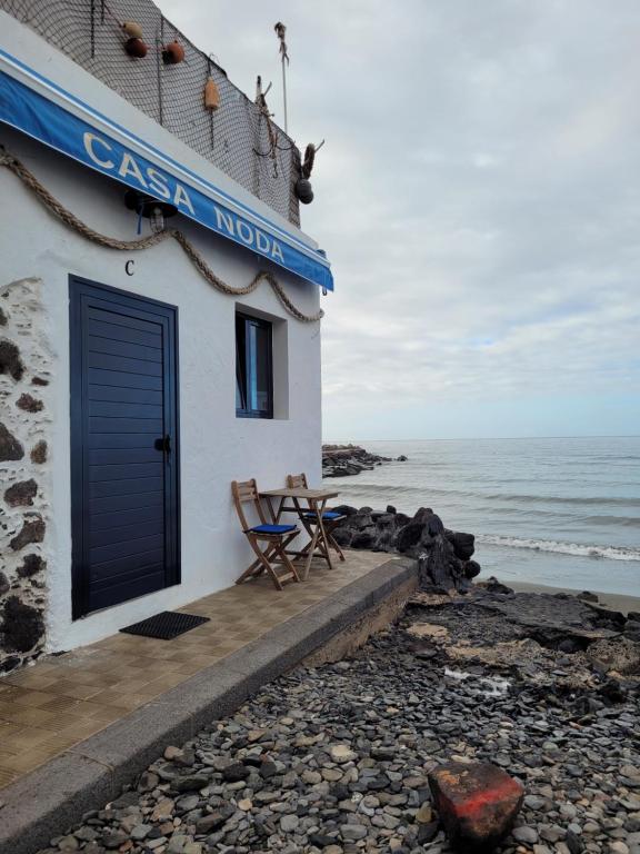 a building with a table and chairs on the beach at Casa Noda Tarajalejo in Tarajalejo