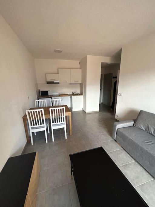 un salon avec un canapé, une table et des chaises dans l'établissement Le Saint Quentin, à Juvignac