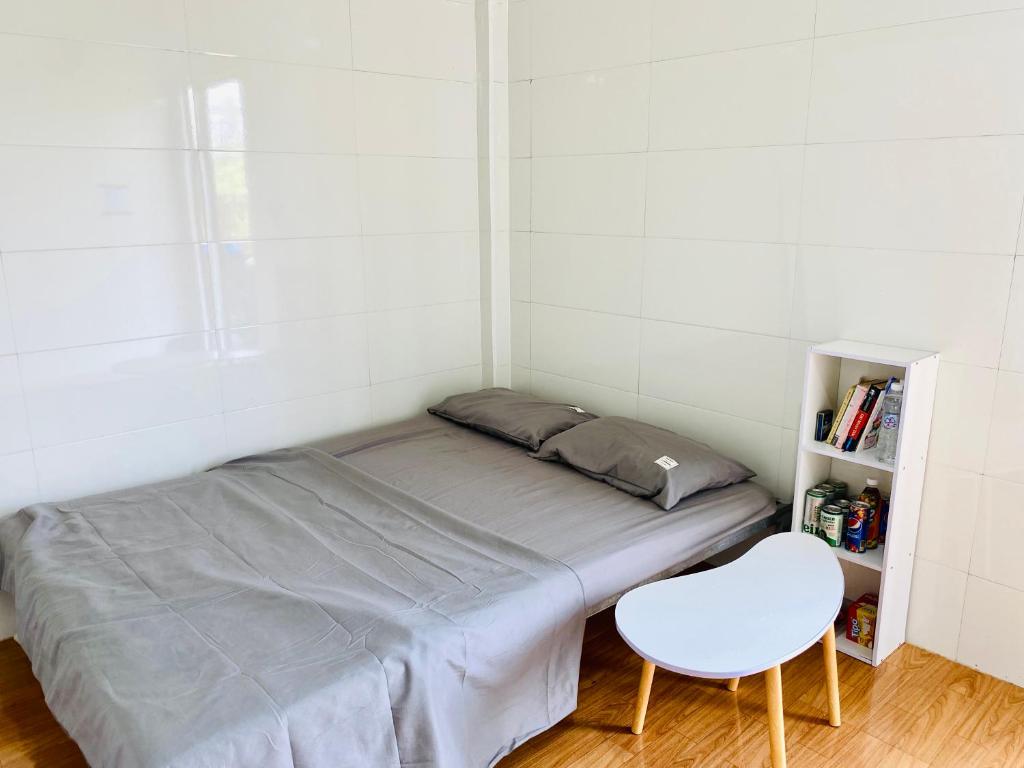 ChuLaLa Khe Sanh في Hương Hóa: غرفة نوم صغيرة بسرير وكرسي أبيض