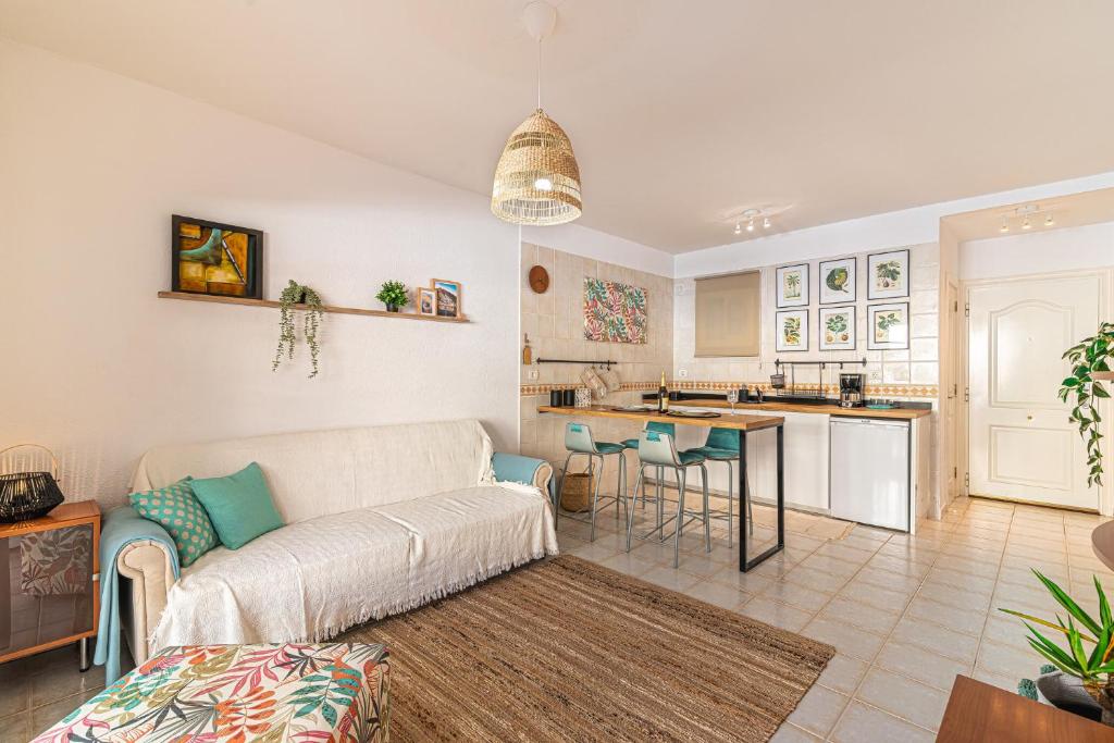een woonkamer met een bank en een keuken bij Los Cristianos El Mirador - As de Casas in Los Cristianos