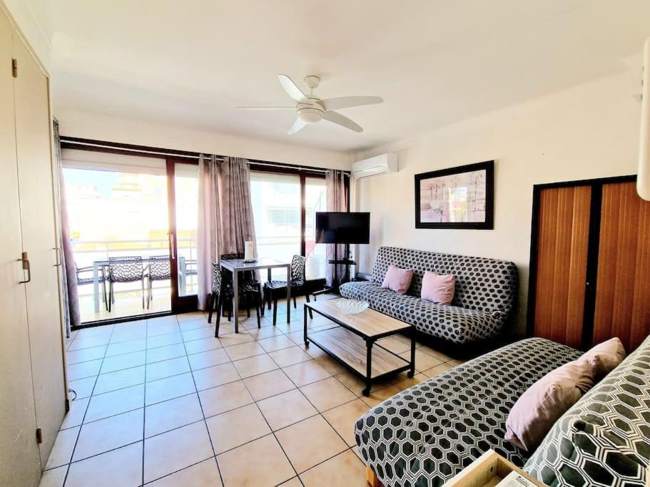 un salon avec un canapé et une table dans l'établissement Hibiscus - plage avec Parking - climatisé - wifi, à Canet