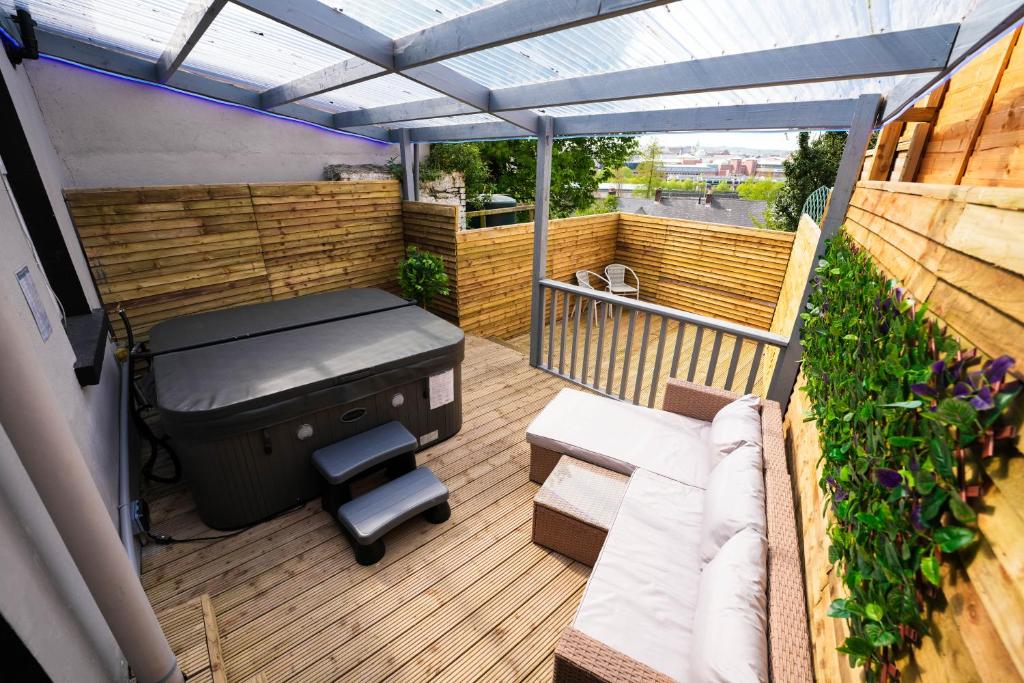 a patio with a bed and a bench on a deck at Luxury Hot Tub Retreat Derry City in Derry Londonderry