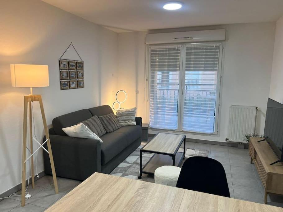 un salon avec un canapé et une table dans l'établissement La Canée, à Juvignac