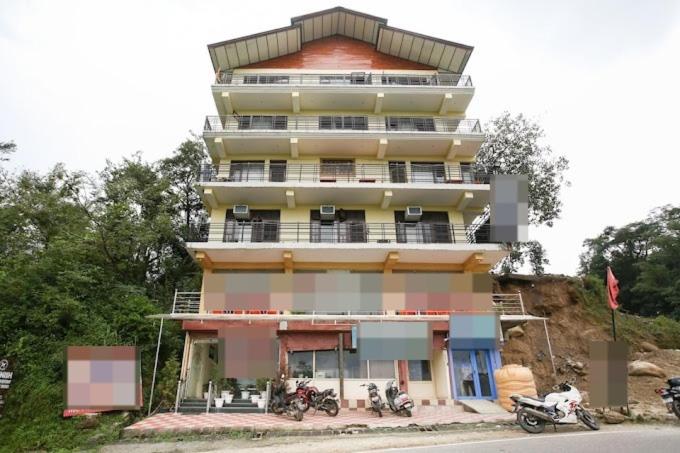 un edificio alto con motos estacionadas frente a él en Hotel Saint, en Pālampur