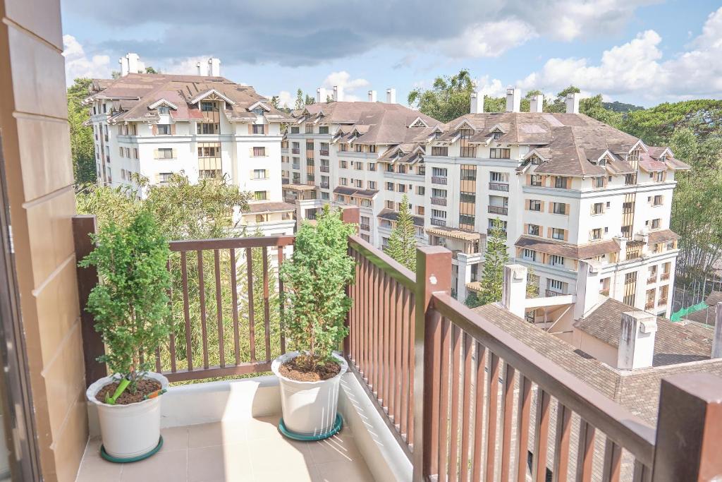 un balcón con 2 plantas y edificios con macetas en QFandZ Baguio Homestay at BRENTHILL Condominium en Baguio