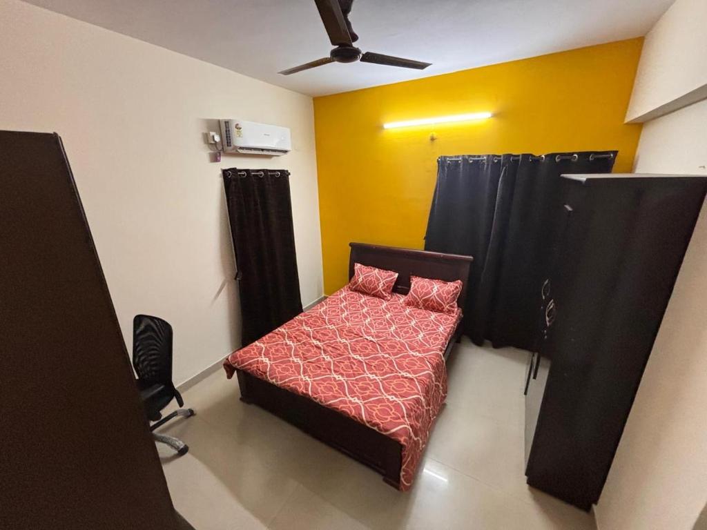 a small bedroom with a bed and a ceiling fan at Kiran parks 101 in Hyderabad