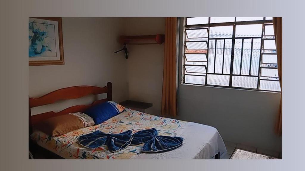 a bedroom with a bed and a window at Hotel Pinheiros in Pinheiros