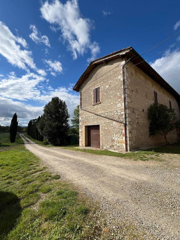 an old stone building on the side of a dirt road at Antica Fonte Eterna - Casale in incantevole contesto Toscano in Colle di Val d'Elsa