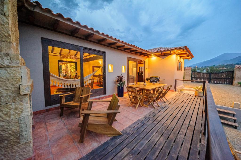 una terraza de madera con mesa y sillas en Casa Bugambilia en Villa de Leyva