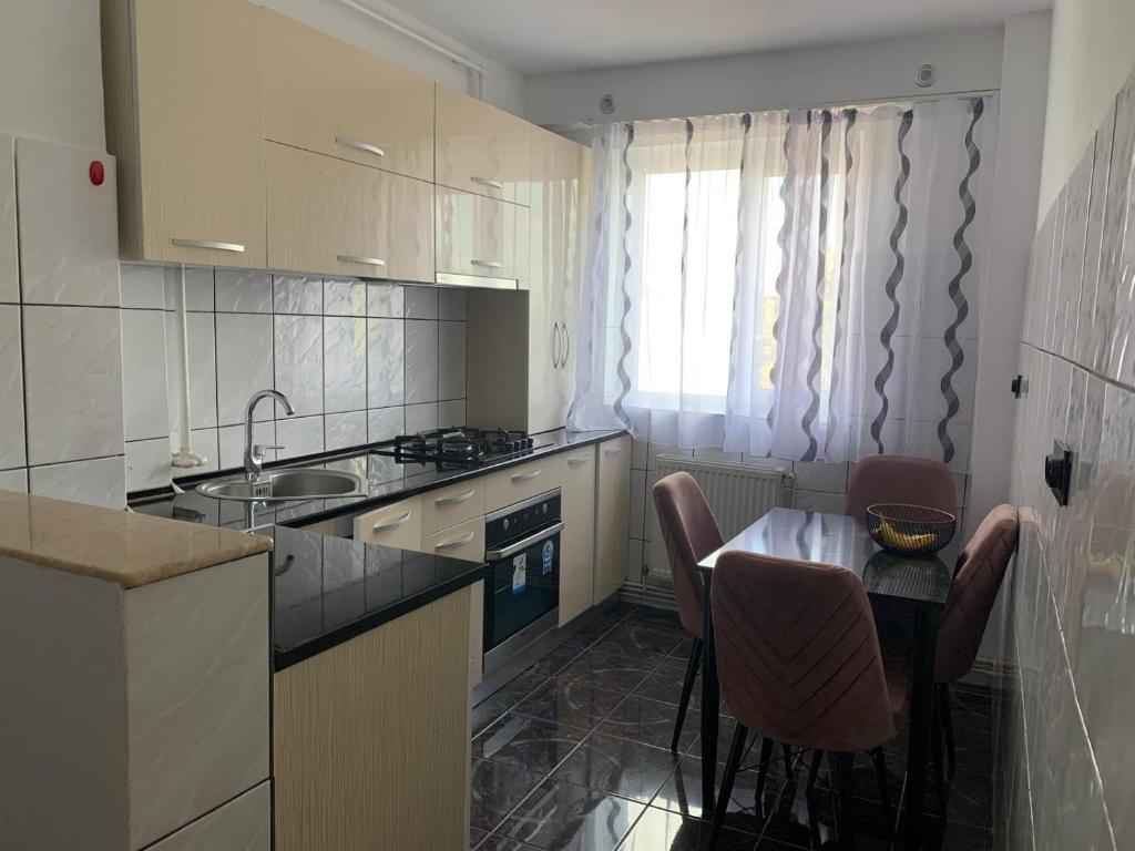 a kitchen with a table and chairs and a sink at Apartament închiriere in Târgovişte