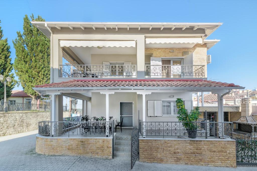 a villa with a balcony in front of it at Nasia House Paliouri in Paliouri