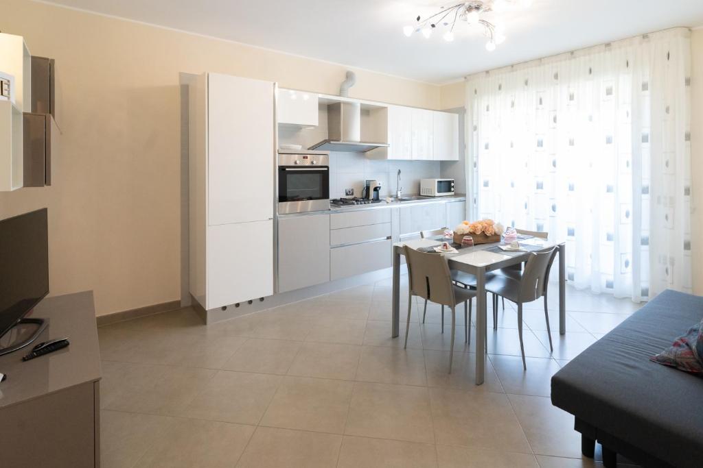 a kitchen and dining room with white cabinets and a table at Seventyfive House in Chioggia