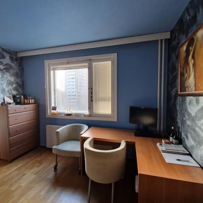 Cette chambre bleue comprend un bureau avec un ordinateur et des chaises. dans l'établissement Pearl of Itä-Pasila, à Helsinki