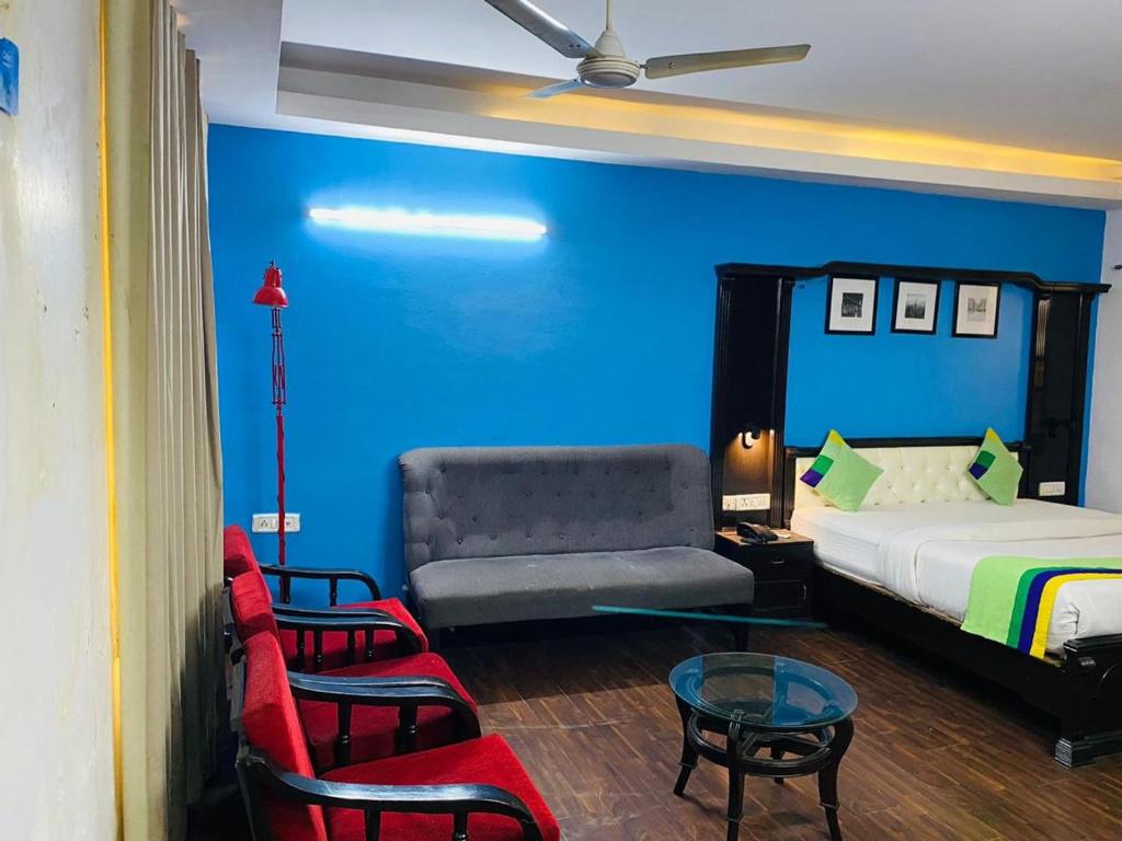 una camera con letto, divano e sedie di Hotel Fabstays-Safdarjung Enclave a Nuova Delhi