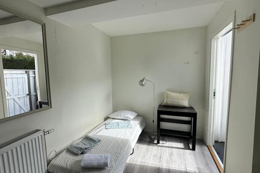 a room with a mirror and a bed and a table at Superhomes 1 gäst in Gothenburg